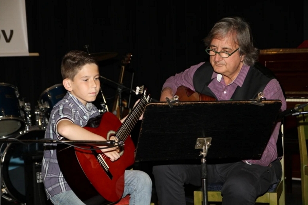teacher playing guitar with a boy